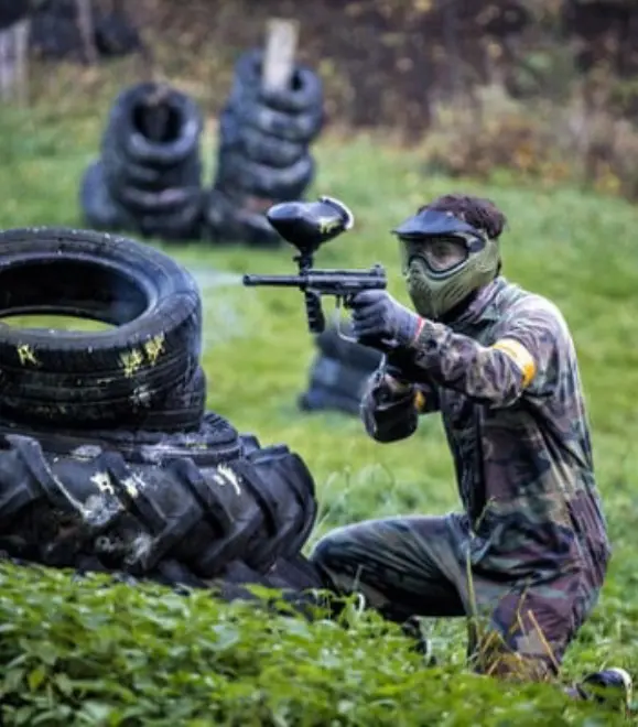 Group playing paintball in outdoor combat field