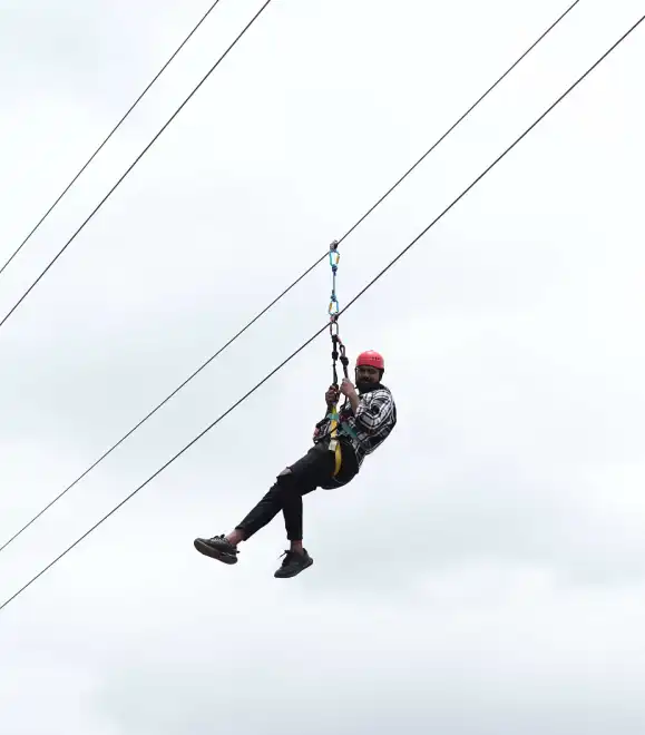 Person gliding on a high zipline at adventure park
